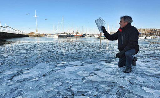 英国一海港因气温骤降海面结冰似玻璃碎片